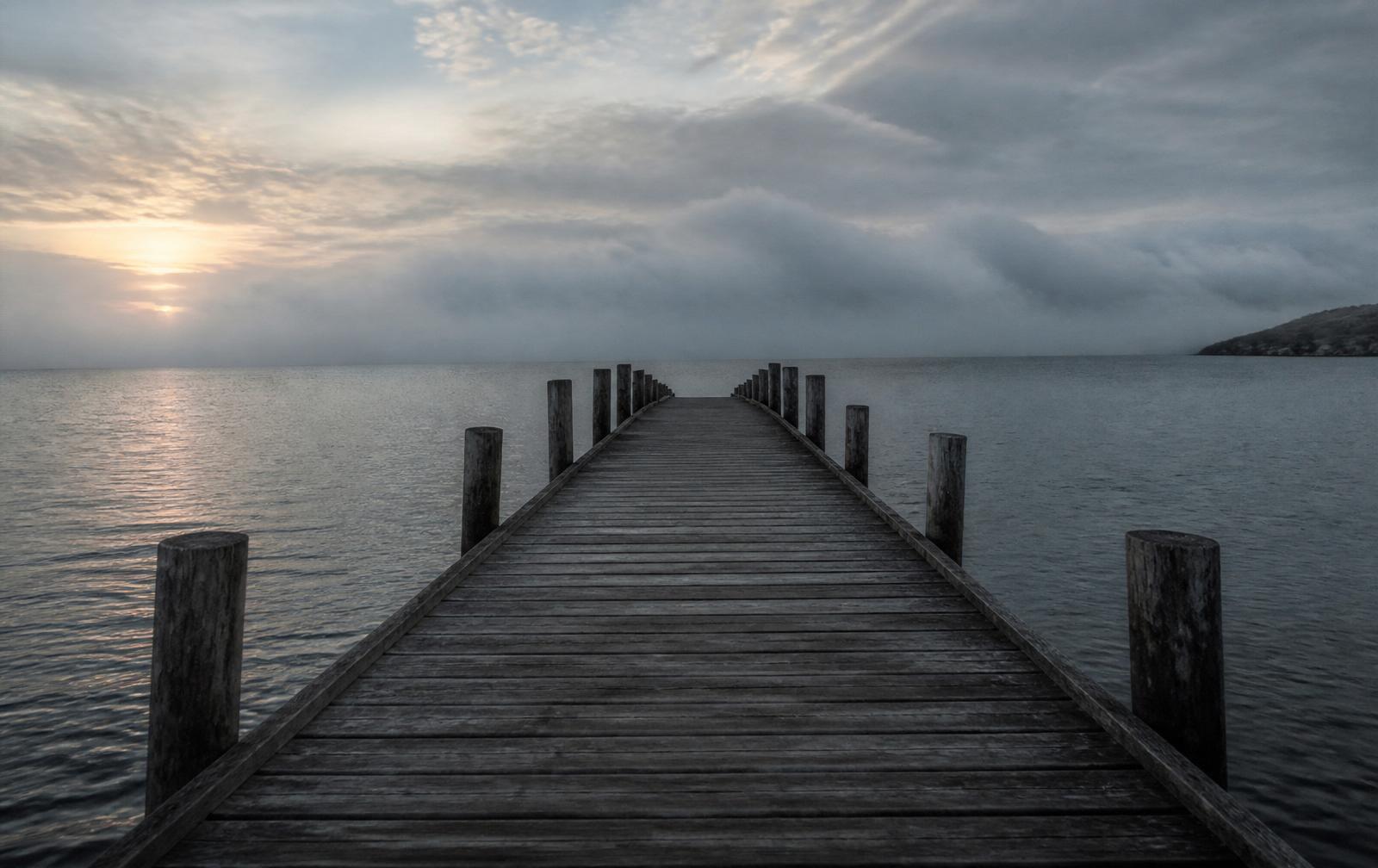 Weathered pier extending into a calm sea